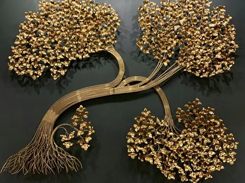 Sculpture murale en métal doré représentant un arbre, au tronc de tiges soudées et au feuillage de milliers de feuilles découpées