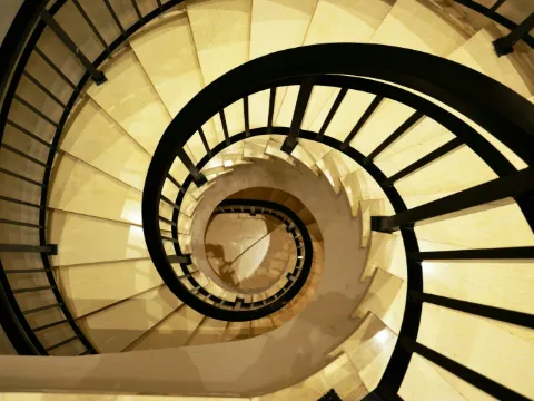 Spirale d'un escalier colimaçon à garde-corps en fer noir, vue depuis le haut